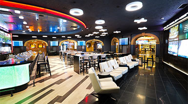 Sportsbook with lounge chairs, bar and tables 
