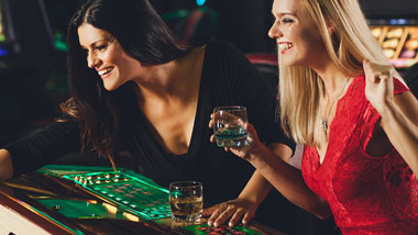 two women playing a game with drinks