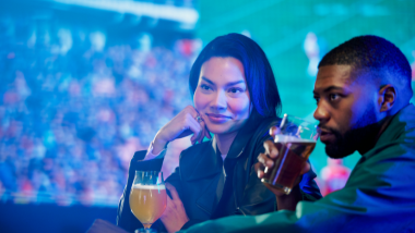 Two people watching sports and drinking beer