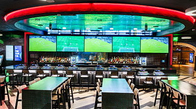 Sportsbook dining area with tables and screens at the bar
