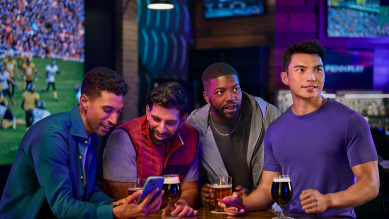 People watching tv in a bar, deinking beer and on their phones