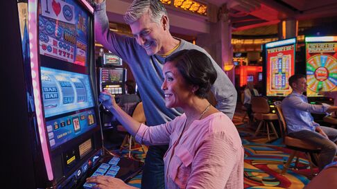 Two people playing on a slot machine
