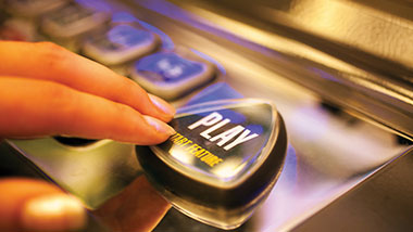 Woman presses the play button on a slot machine