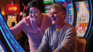 couple playing at a slot machine